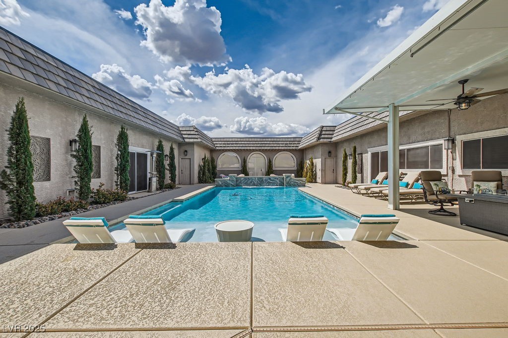 Outdoor pool with a patio and ceiling fan
