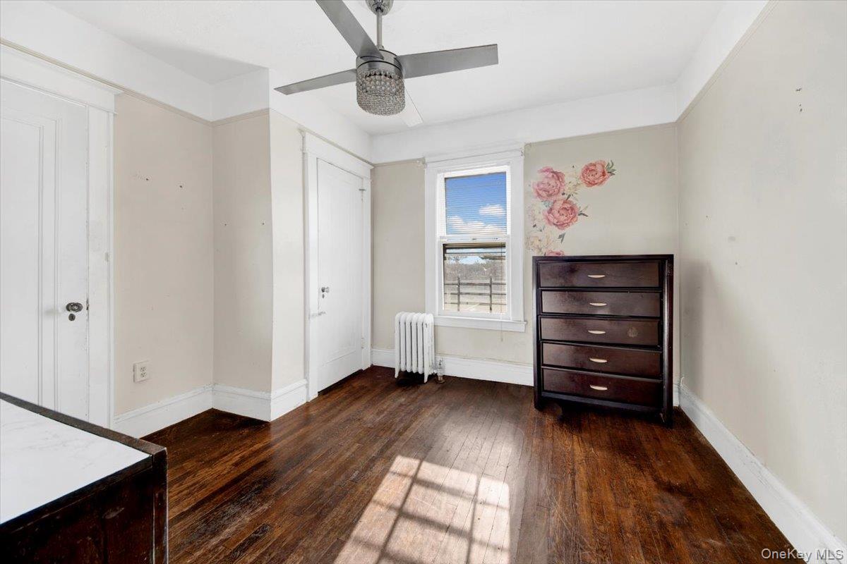 2312 Morgan Avenue Bronx, NY 10469 - Photo 23 of 36 Unfurnished bedroom featuring radiator heating unit, dark wood-style flooring, and a ceiling fan