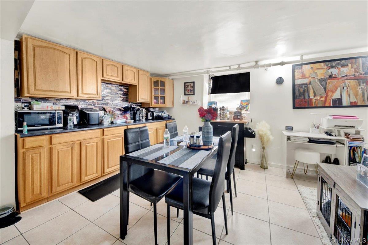 2312 Morgan Avenue Bronx, NY 10469 - Photo 32 of 36 Kitchen with dark countertops, glass insert cabinets, tasteful backsplash, and light tile patterned flooring