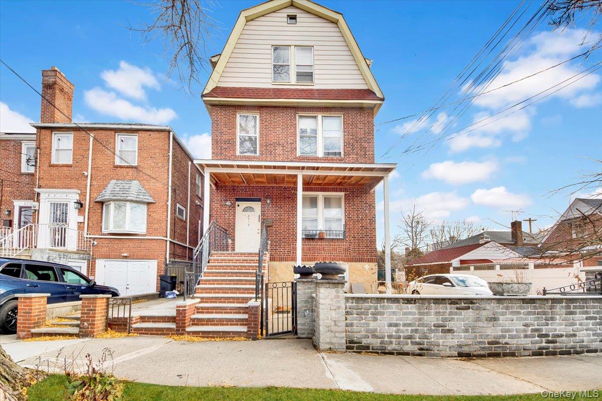 2312 Morgan Avenue Bronx, NY 10469 - Photo 35 of 36 View of front of home with a gambrel roof, brick siding, a gate, and a fenced front yard