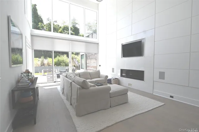 a living room with fireplace furniture and a floor to ceiling window