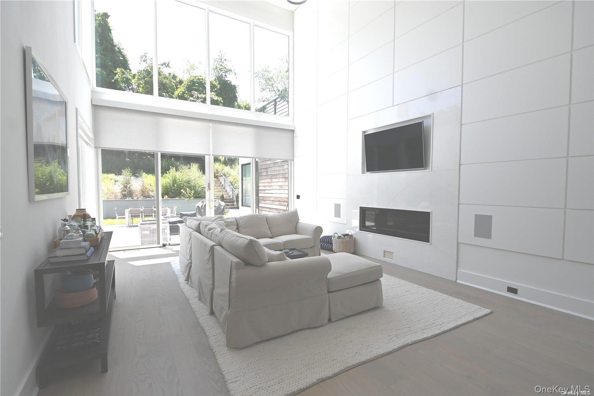 43 Smugglers Path Riverhead, NY 11901 - Photo 5 of 17 a living room with fireplace furniture and a floor to ceiling window