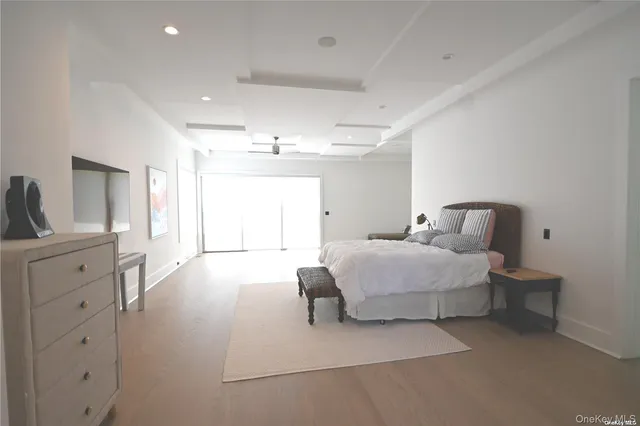 a spacious bedroom with a bed and a lamp