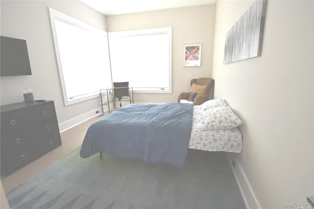 a bedroom with a bed and a flat tv screen on the dresser