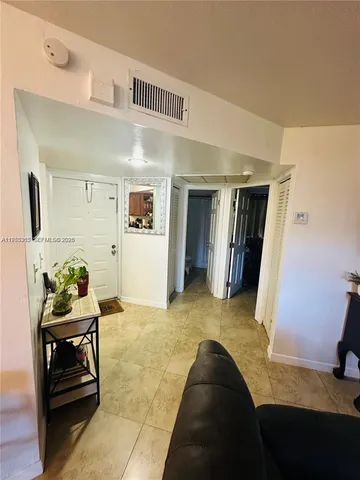 a living room with furniture and a baby crib