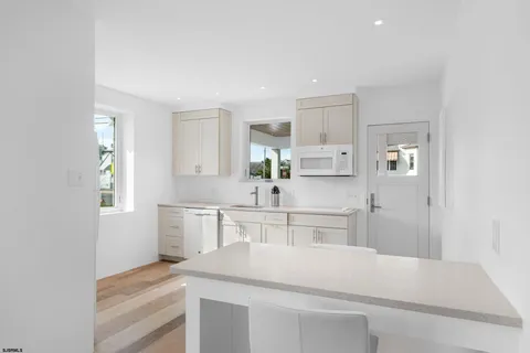 a kitchen with white cabinets and white appliances