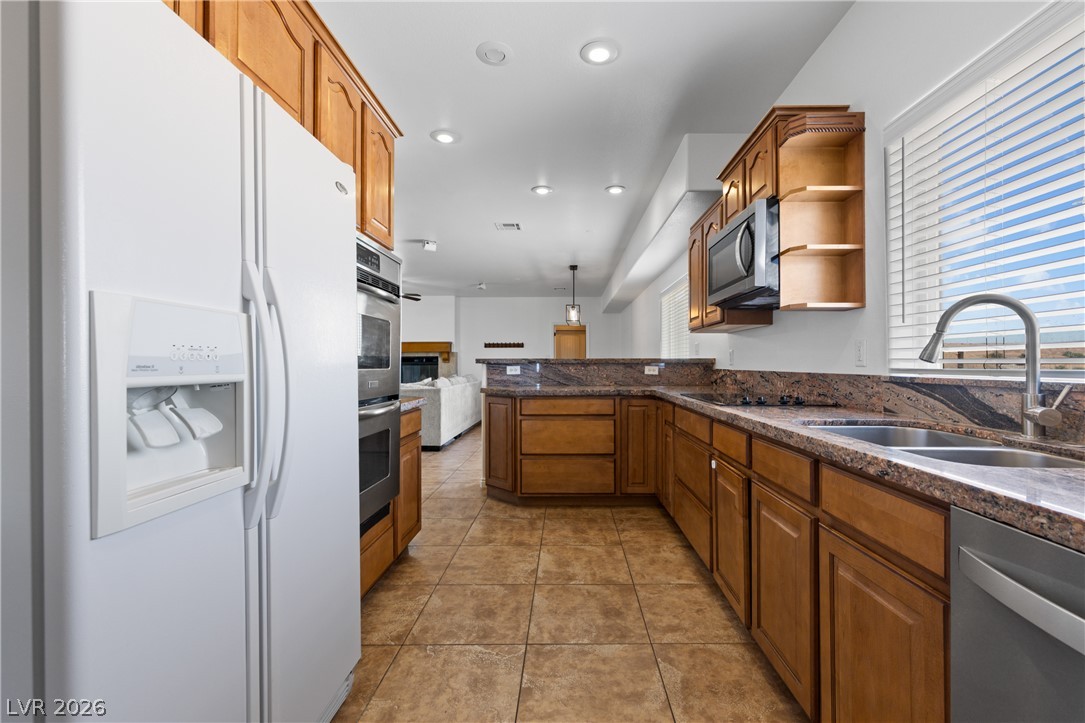 575 Gann Avenue Logandale, NV 89021 - Photo 18 of 75 A well-appointed kitchen showcasing durable tile flooring and rich wood cabinetry, perfect for culinary endeavors.