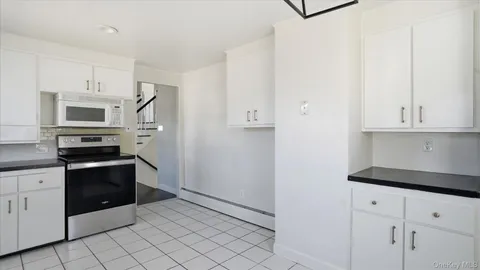 a kitchen with granite countertop white cabinets and stainless steel appliances