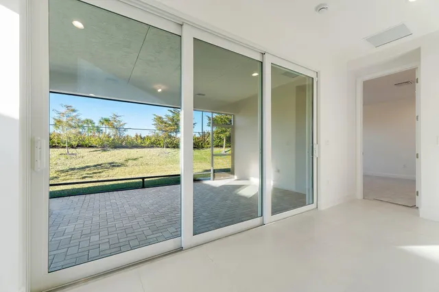 a view of a room with wooden floor and a floor to ceiling window