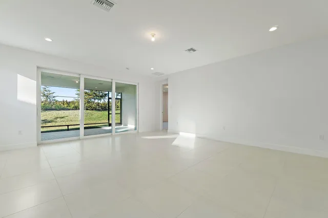 a view of an empty room with wooden floor and fence