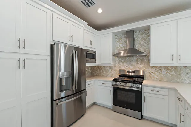 a kitchen with stainless steel appliances a refrigerator stove and sink