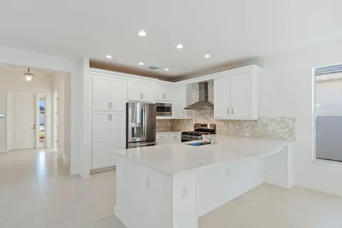 a kitchen with stainless steel appliances a refrigerator sink and white cabinets