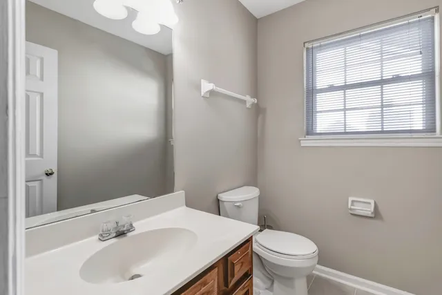 a bathroom with a sink a toilet and a mirror