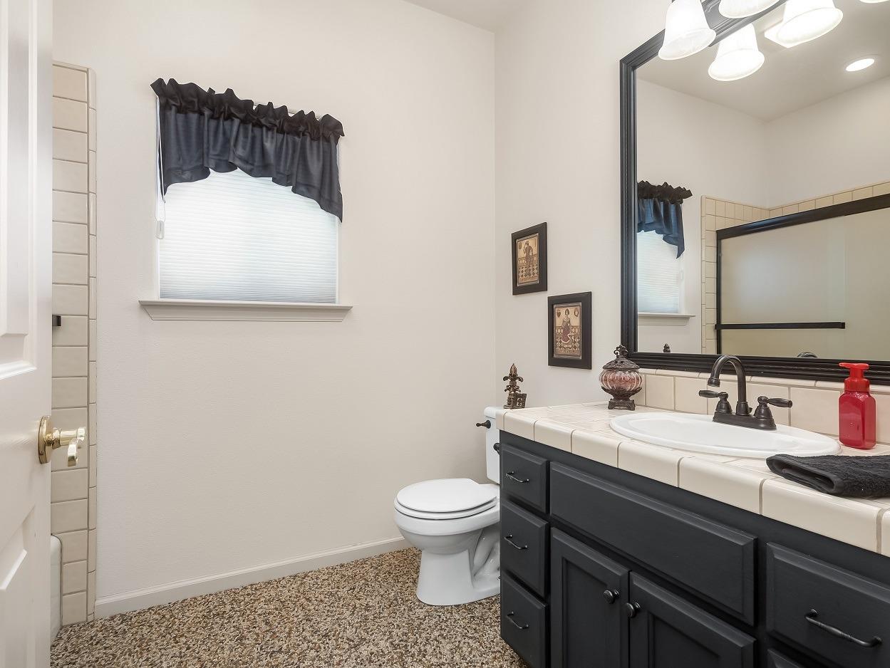 602 Fallbrook Avenue Clovis, CA 93611 - Photo 35 of 51 a bathroom with a sink a toilet and mirror