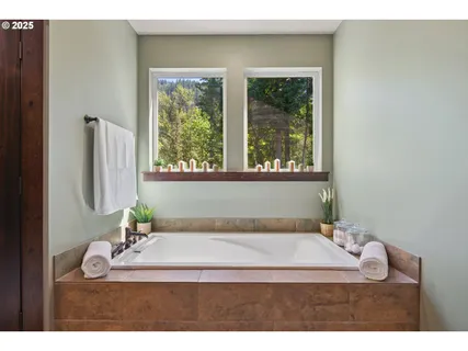 a bathroom with a granite countertop sink a mirror and a bathtub