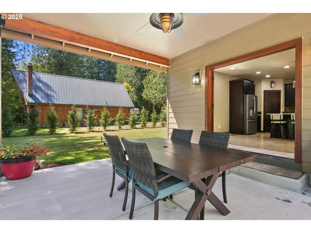 a view of a patio with a table chairs and a yard