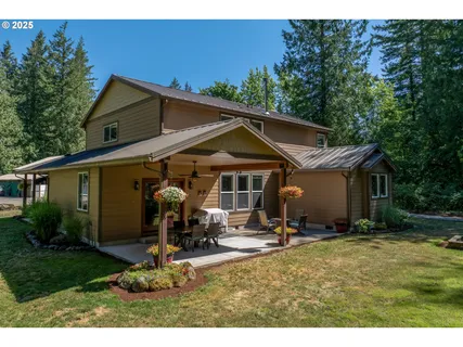 a view of a house with backyard and trees