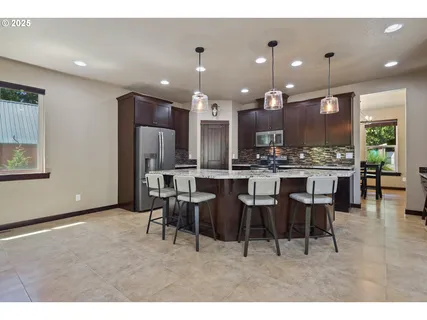 a large kitchen with a table and chairs