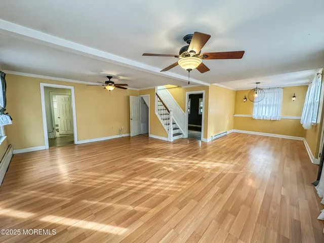 a view of a livingroom with wooden floor and a ceiling fan
