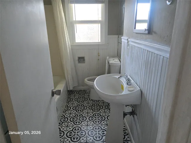 a bathroom with a sink a toilet and a mirror