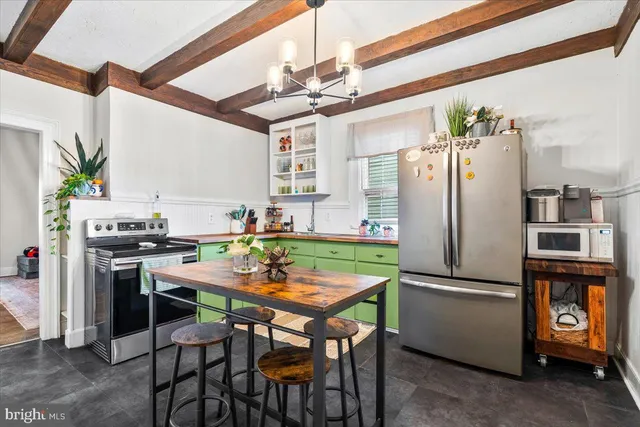 a kitchen with stainless steel appliances kitchen island a table and chairs in it