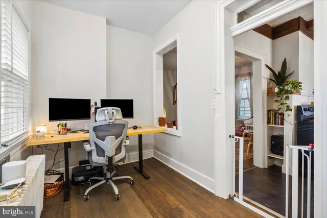 a view of a workspace with furniture and a window