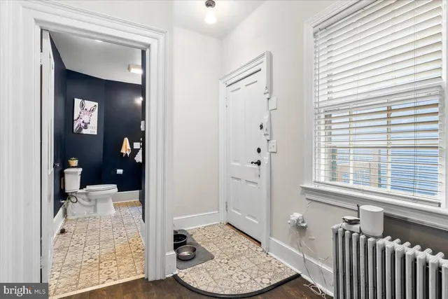 a view of a hallway view with wooden floor and a living room