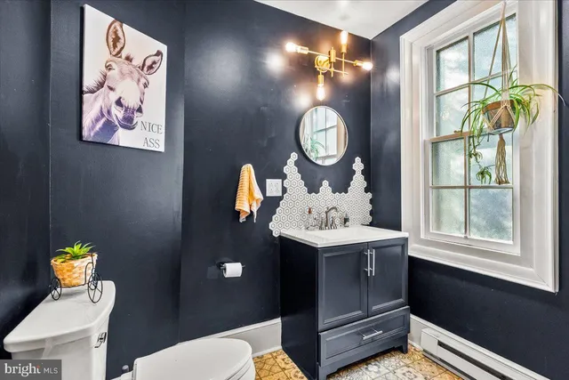 a bathroom with a sink mirror vanity and toilet
