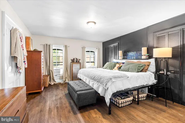a spacious bedroom with a bed and wooden floor