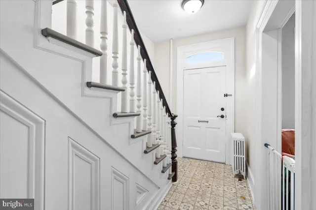 a view of staircase with lots of frames on wall and a window