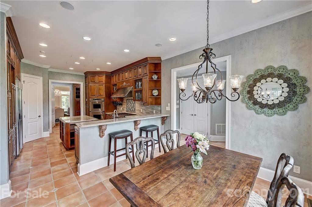 13710 Robert Walker Drive Davidson, NC 28036 - Photo 20 of 48 a kitchen with stainless steel appliances granite countertop a sink counter space dining table and chairs