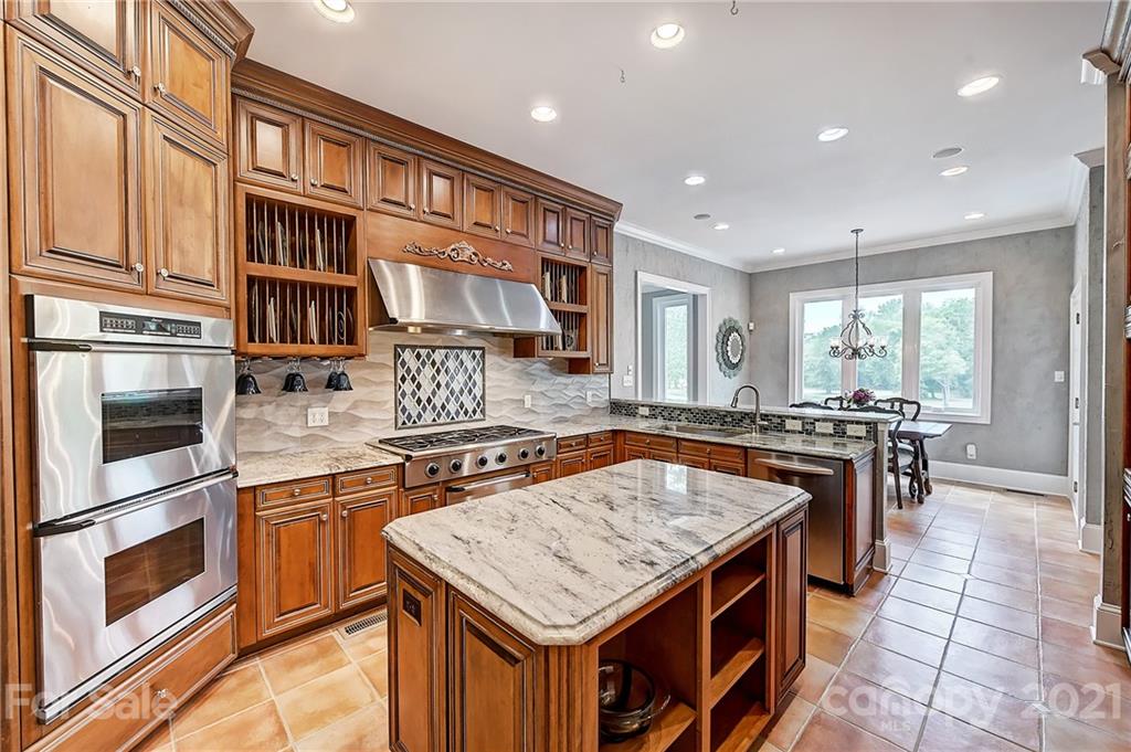 13710 Robert Walker Drive Davidson, NC 28036 - Photo 22 of 48 a kitchen with stainless steel appliances granite countertop a stove top oven a sink dishwasher and cabinets with wooden floor