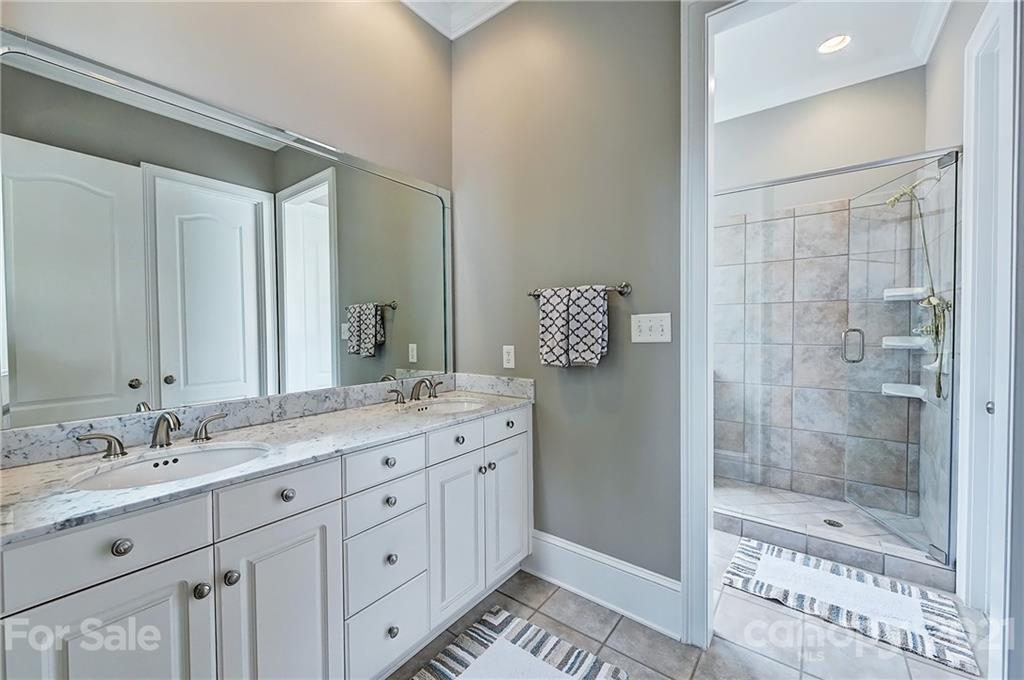 13710 Robert Walker Drive Davidson, NC 28036 - Photo 33 of 48 a bathroom with a shower sink and mirror
