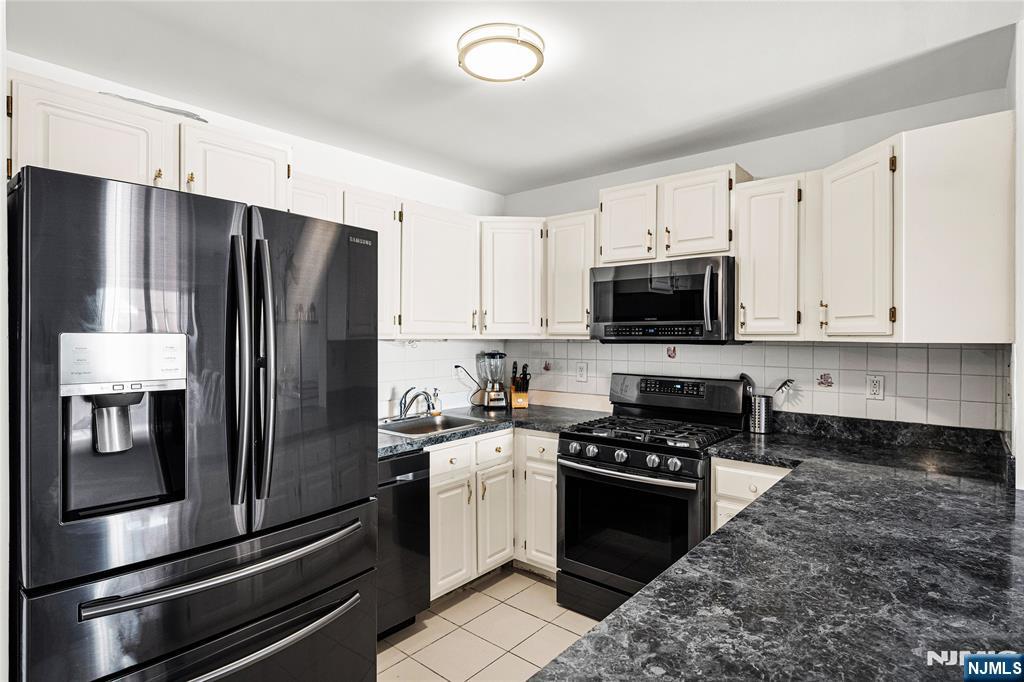 84 Union Street Newark, NJ 07105 - Photo 18 of 39 a kitchen with a refrigerator stainless steel appliances and white cabinets