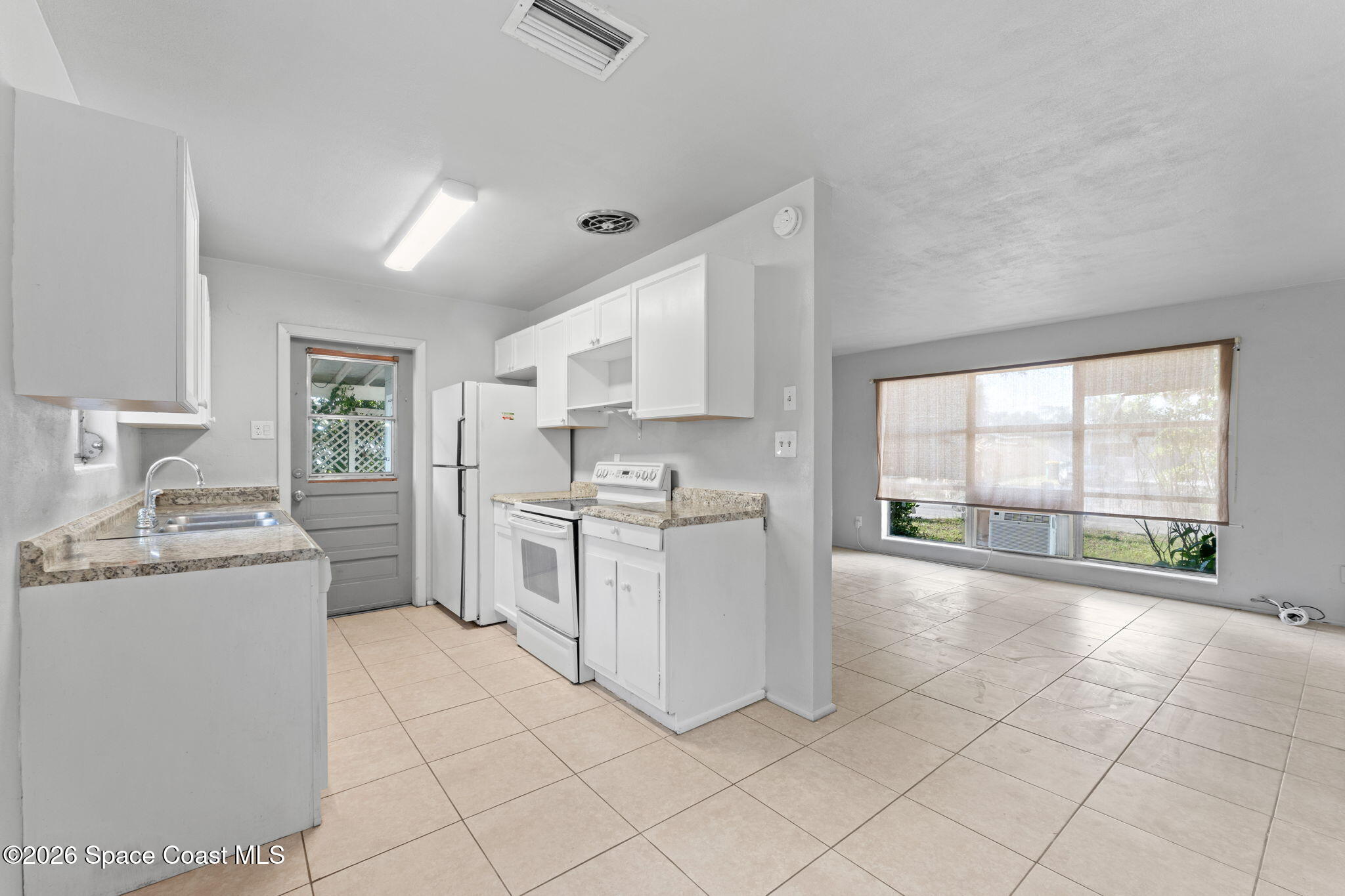 1042 Azalea Lane Cocoa, FL 32922 - Photo 9 of 26 a large white kitchen with a stove a sink dishwasher and a refrigerator