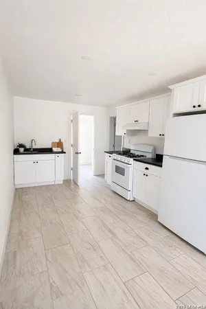 a kitchen with stainless steel appliances a refrigerator sink and white cabinets