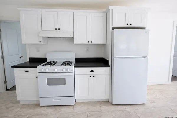 a kitchen with cabinets and white appliances
