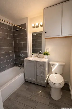 a bathroom with a sink toilet vanity and tub