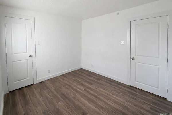 a view of an empty room with wooden floor