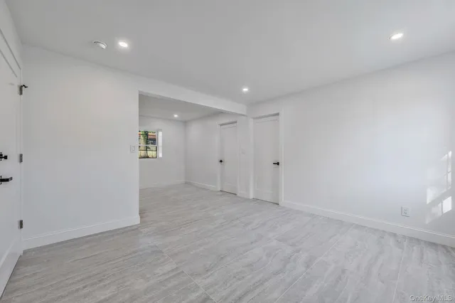 a view of a big room with wooden floor and windows