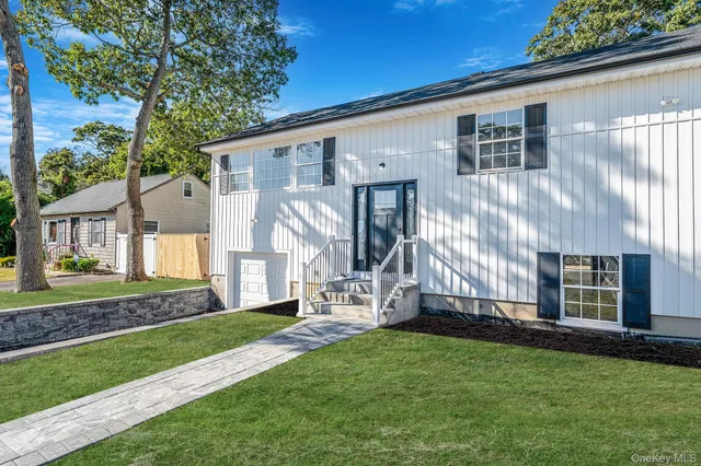 a large white kitchen with kitchen island a sink a stove a refrigerator and white cabinets with wooden floor