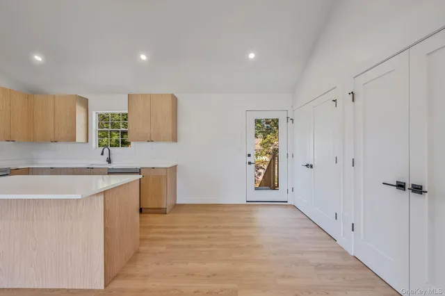 a view of a kitchen with kitchen island a sink wooden floor and a window