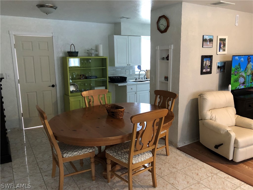 208 Davis Road Lehigh Acres, FL 33936 - Photo 13 of 20 a view of a dining room with furniture and wooden floor