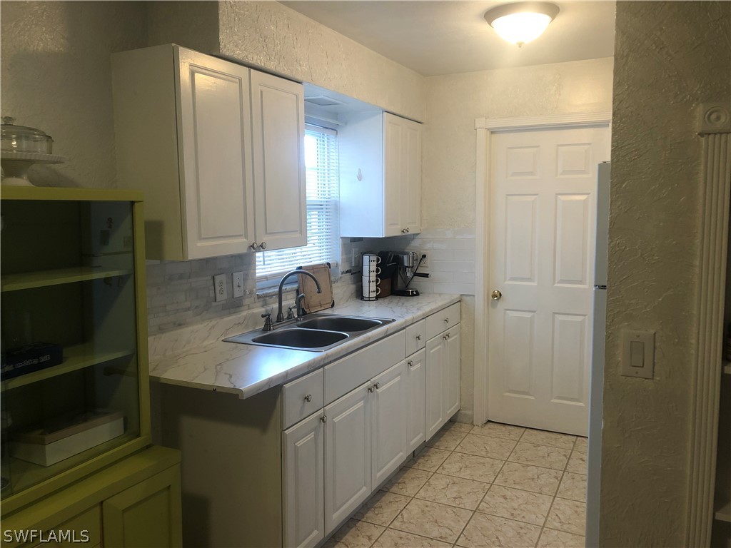 208 Davis Road Lehigh Acres, FL 33936 - Photo 15 of 20 a kitchen with a sink and cabinets