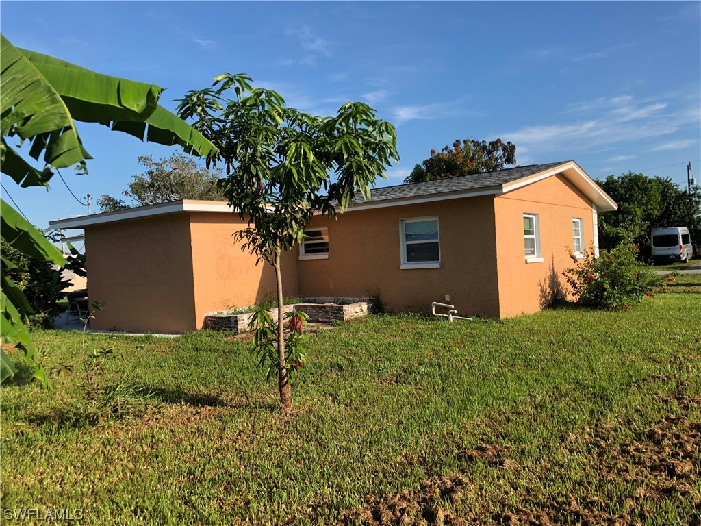 208 Davis Road Lehigh Acres, FL 33936 - Photo 19 of 20 a house that has a tree in front of it
