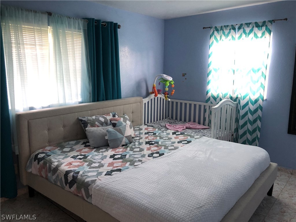 208 Davis Road Lehigh Acres, FL 33936 - Photo 8 of 20 a bedroom with a bed and a window