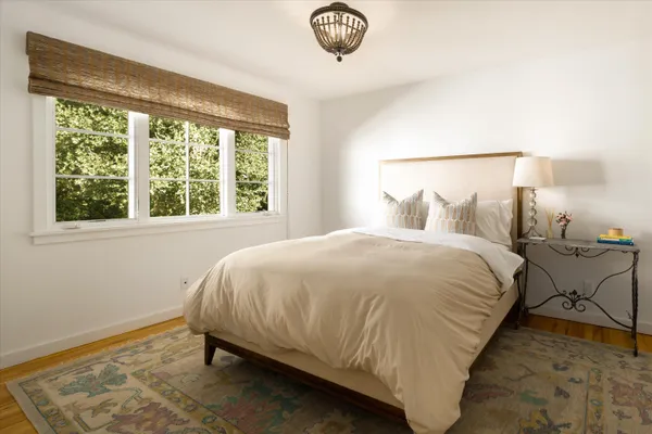 a bed sitting in a bedroom next to a window