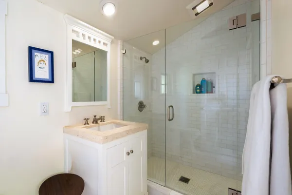 a bathroom with a shower sink and mirror