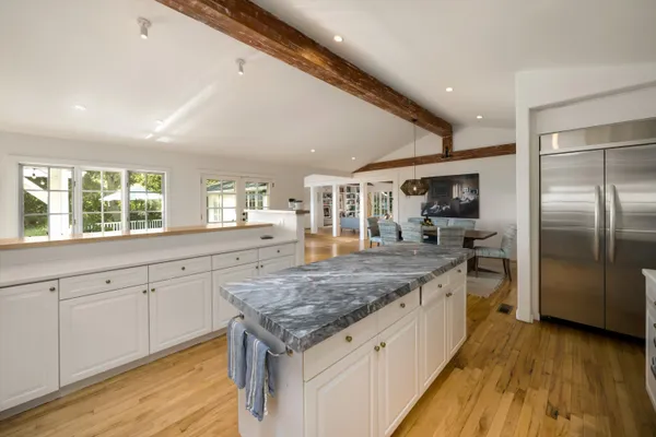 a large kitchen with a center island and stainless steel appliances