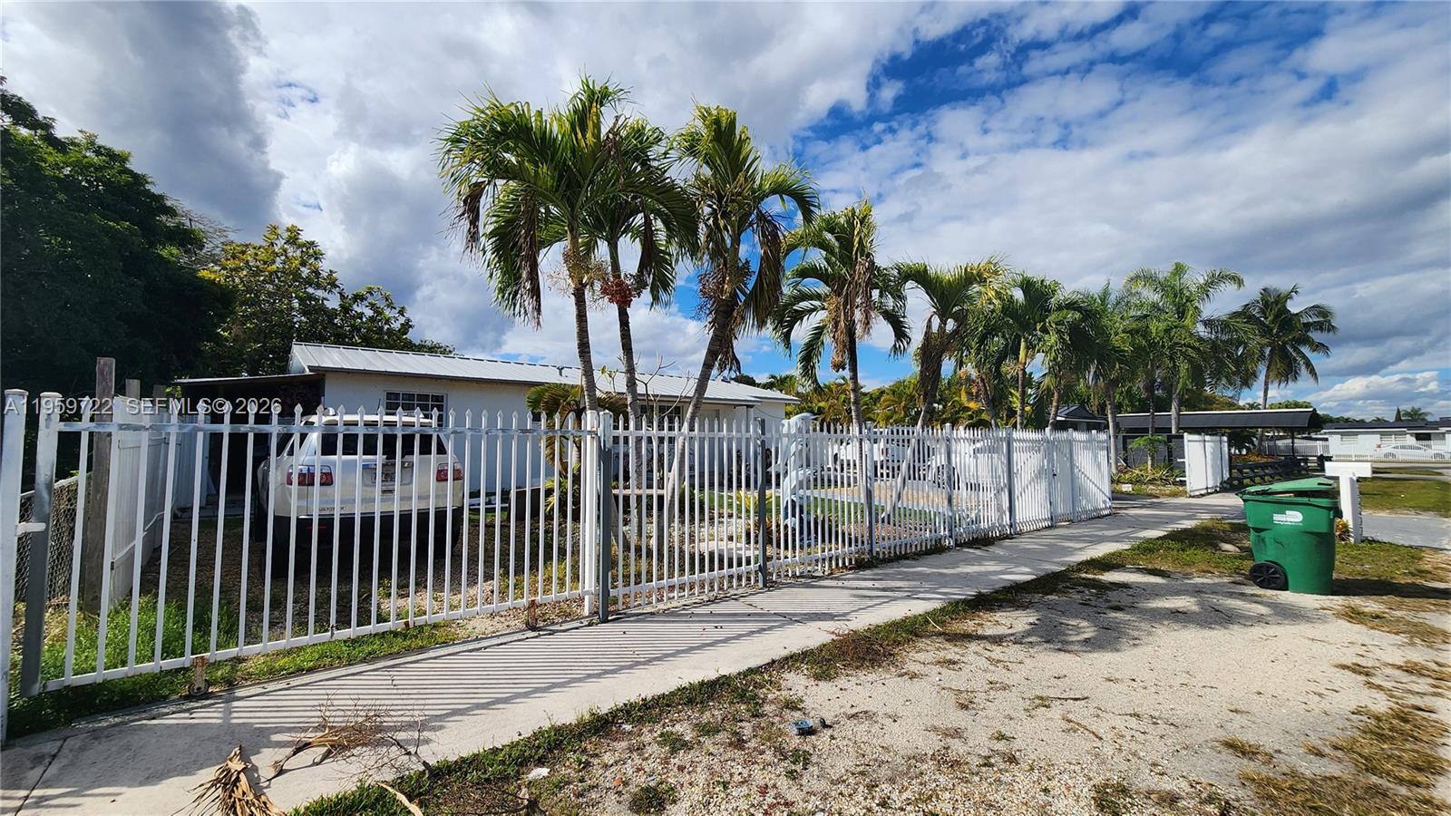 20022 Southwest 118th Avenue Miami, FL 33177 - Photo 22 of 23 a view of a house with a small yard and wooden fence